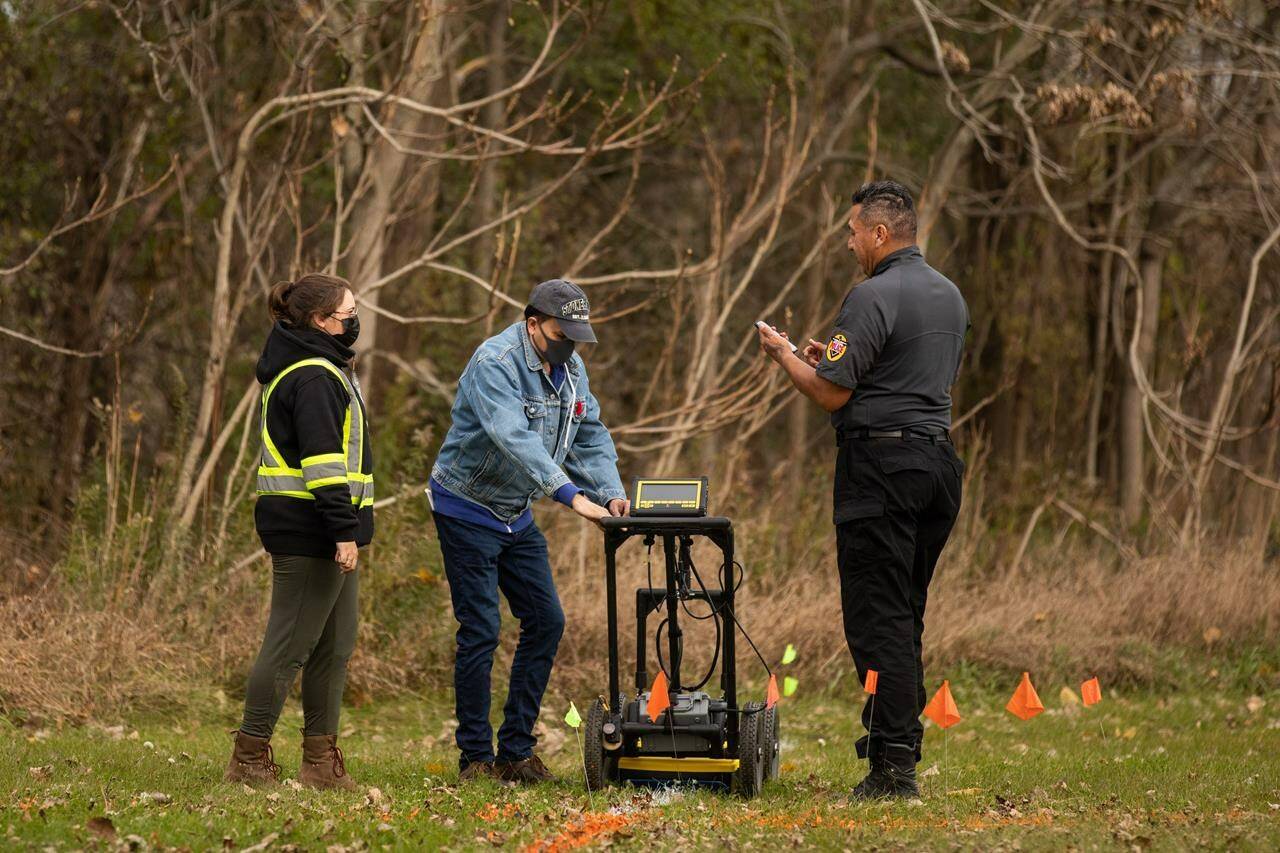 Community members, joined by Six Nations Police, conduct a search for unmarked graves using ground-penetrating radar on the 500 acres of the lands associated with the former Indian Residential School, the Mohawk Institute, in Brantford, Ont., Tuesday, Nov. 9, 2021. Indigenous communities searching for unmarked graves have seen a rise in individuals denying the disappearances and deaths of Indigenous children in the residential school system, according to a new report from the federal government’s special interlocutor on unmarked graves. THE CANADIAN PRESS/Nick Iwanyshyn