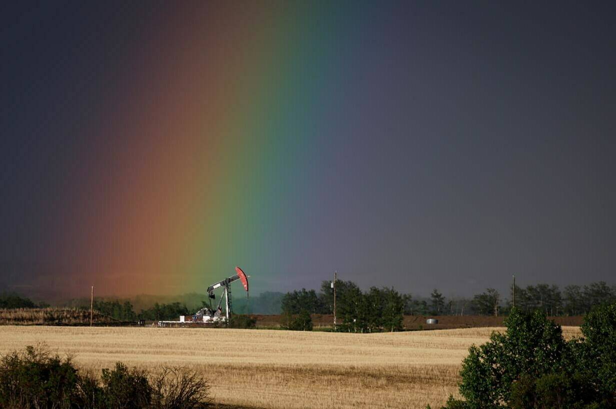 A pumpjack draws out oil and gas from a well head as a rainbow shines down on it near Calgary, Alta., Sunday, May 28, 2023. New modelling from the Canada Energy Regulator suggests Canadian oil production will plummet by 2050 if the world achieves net-zero greenhouse gas emissions within that time. THE CANADIAN PRESS/Jeff McIntosh