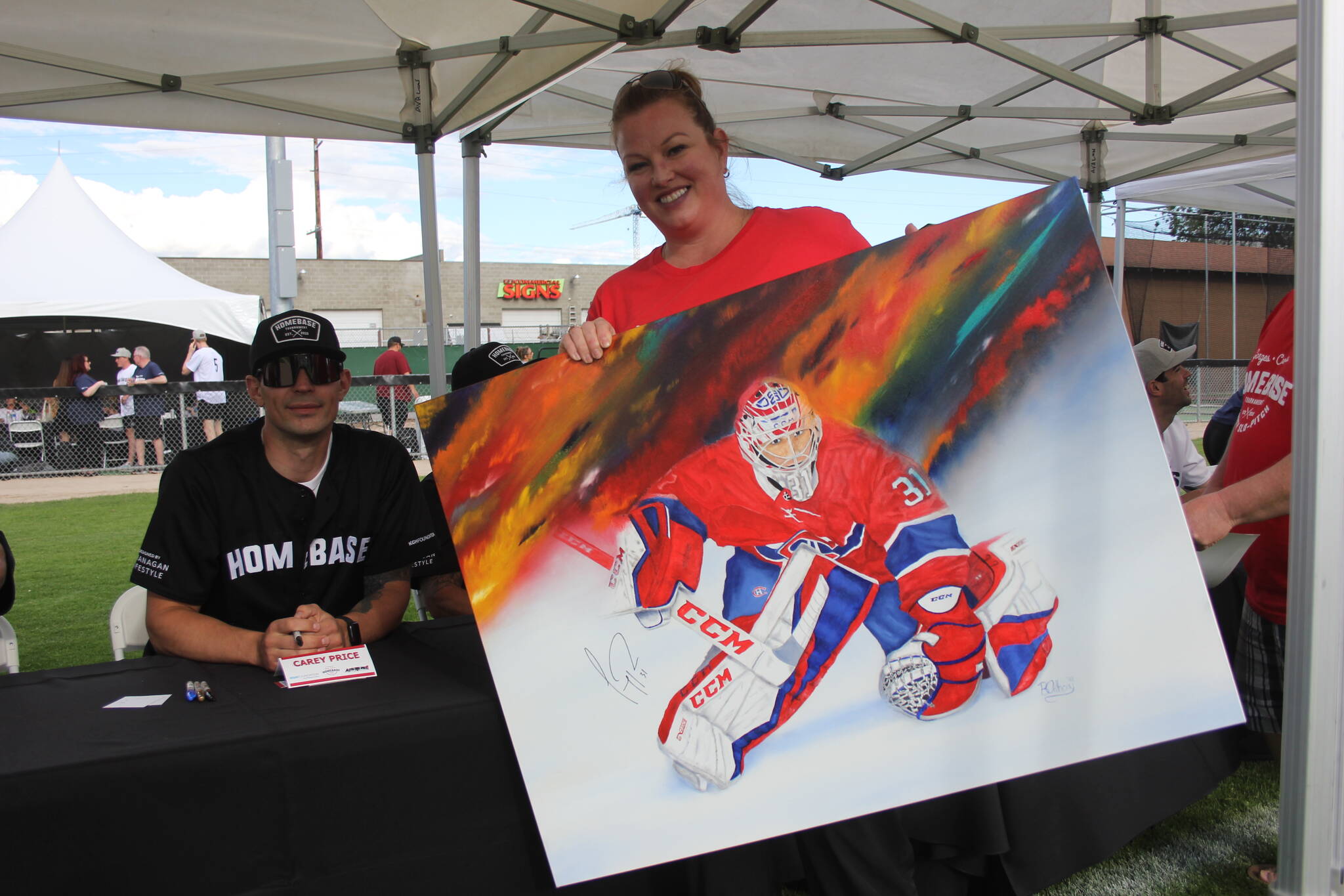 A fan presents her self-drawn Carey Price painting to the goaltender at Homebase 2022 in Kelowna. (Jake Courtepatte/Capital News)