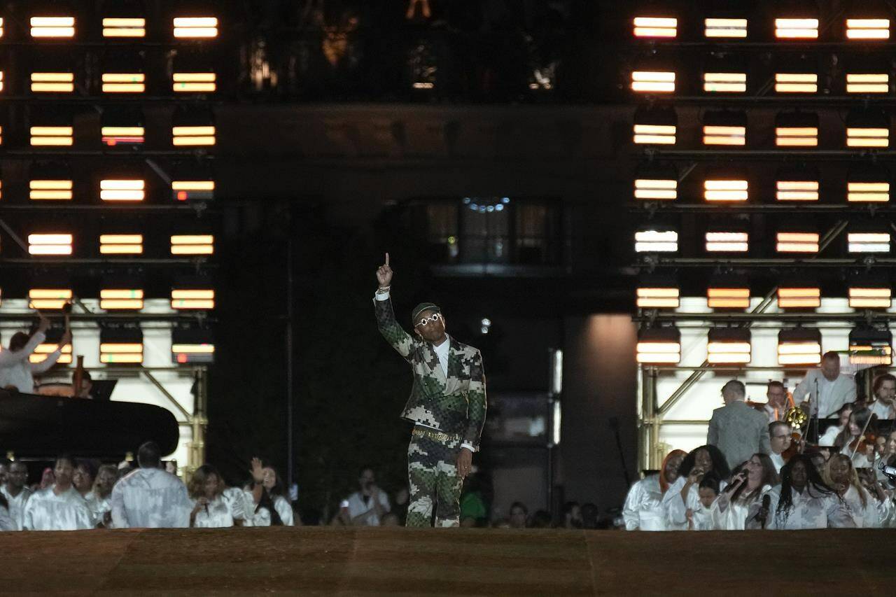 Designer Pharrell Williams accepts applause at the conclusion of the Louis Vuitton Menswear Spring/Summer 2024 fashion collection presented in Paris, Tuesday, June 20, 2023. (AP Photo/Christophe Ena)