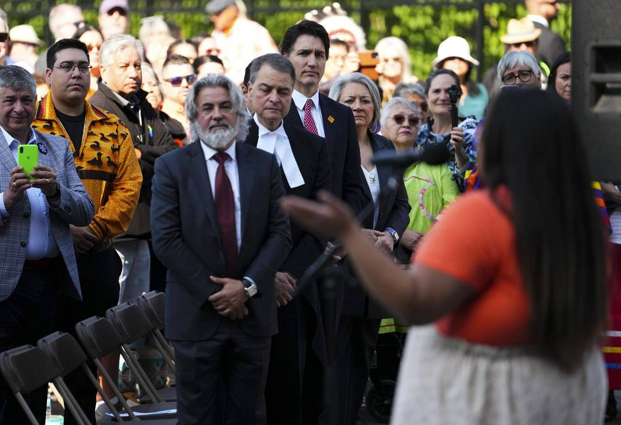 Prime Minister Justin Trudeau and Governor General Mary Simon look on as First Nations Artis Alicia Kayley performs during the site selection ceremony of the Residential Schools National Monument on Parliament Hill in Ottawa on Tuesday, June 20, 2023. The federal government has released its action plan on implementing the United Nations Declaration on the Rights of Indigenous Peoples. THE CANADIAN PRESS/Sean Kilpatrick