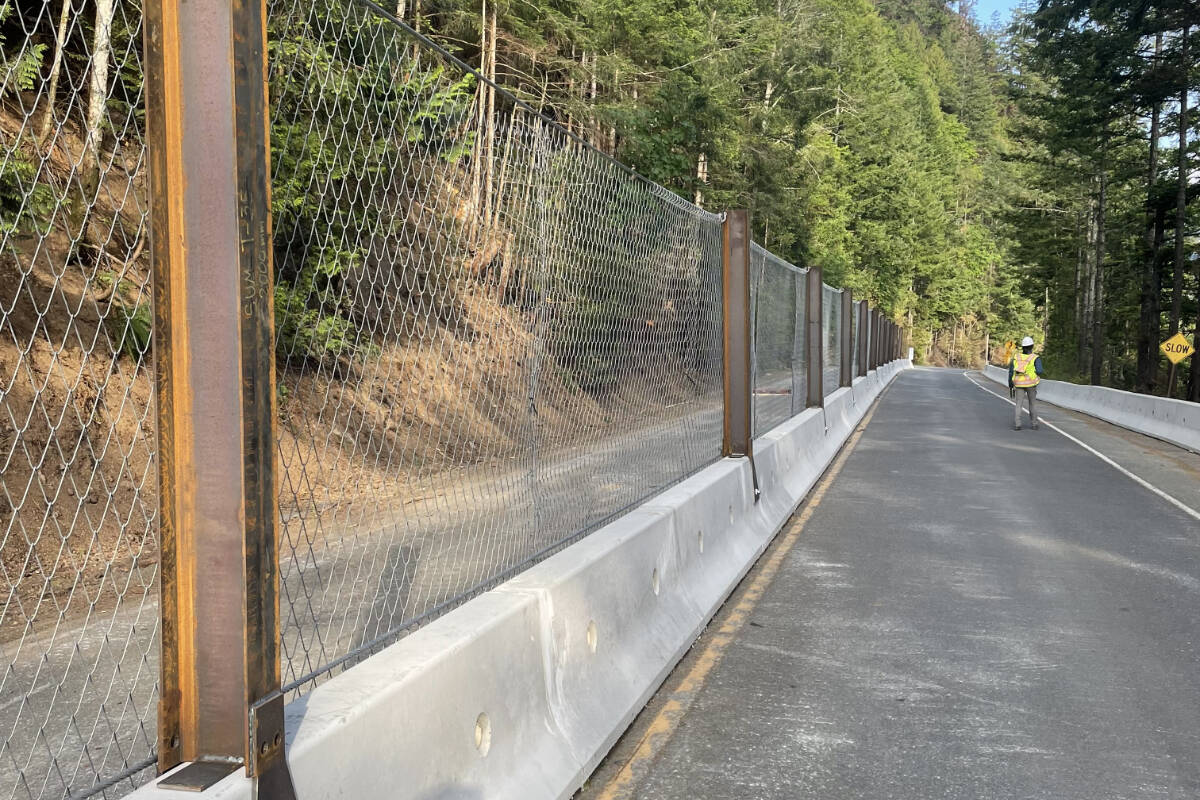 Workers put finishing touches on protective barriers along a two-kilometre stretch of Highway 4 where the Cameron Bluffs wildfire reached the highway. The Vancouver island highway has been closed since June 6, 2023. (PHOTO COURTESY MINISTRY OF TRANSPORTATION)
