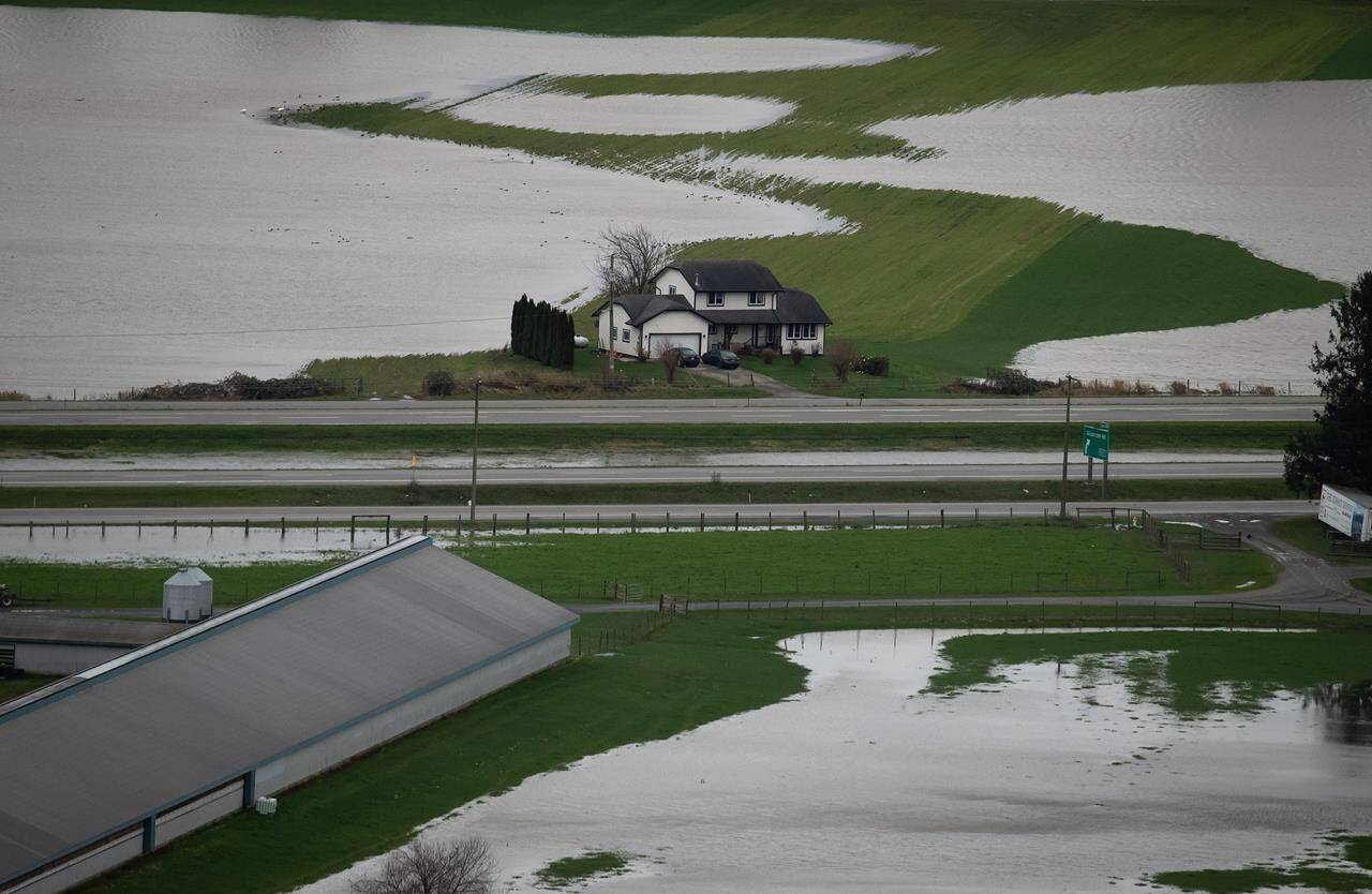 A house sits on high ground among flooded farmland in Abbotsford, B.C., on Wednesday, December 1, 2021. The final version of Canada’s plan to make communities more resilient to the effects of climate change will be released today. THE CANADIAN PRESS/Darryl Dyck