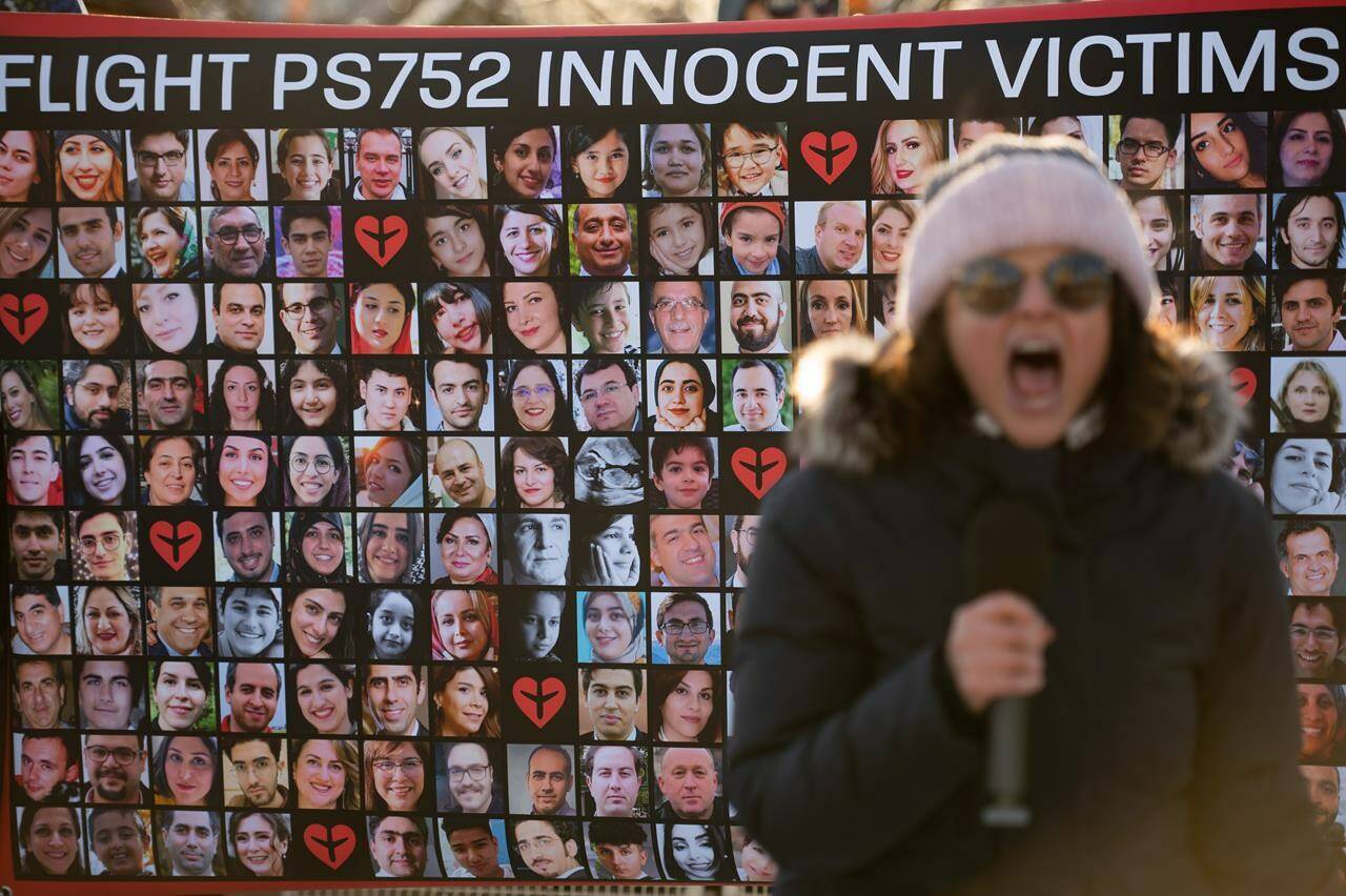 A protestor chants in front of a poster with the faces of the victims of Ukraine International Airlines Flight PS752 in Ottawa, on Sunday, Jan. 8, 2023. Canada is among four countries turning to international law to ensure Iran is held accountable for shooting down Flight PS752 more than three years ago.THE CANADIAN PRESS/Spencer Colby