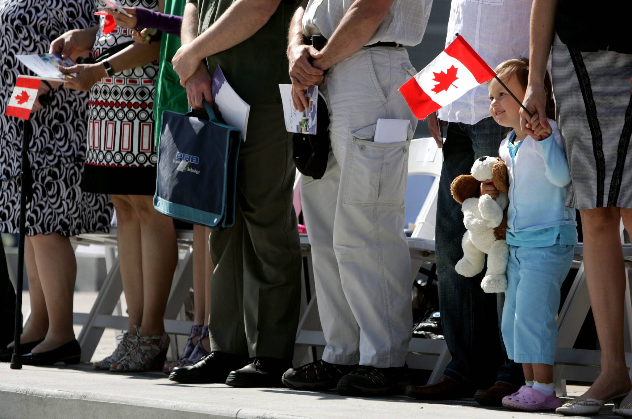 Three-year-old Nina Matriyiv holds a Canadian flag as she attends a citizenship ceremony where her parents and sister, from Ukraine, became citizens with 58 other new Canadians on Canada Day in Vancouver, B.C., on Wednesday July 1, 2009. THE CANADIAN PRESS/Darryl Dyck