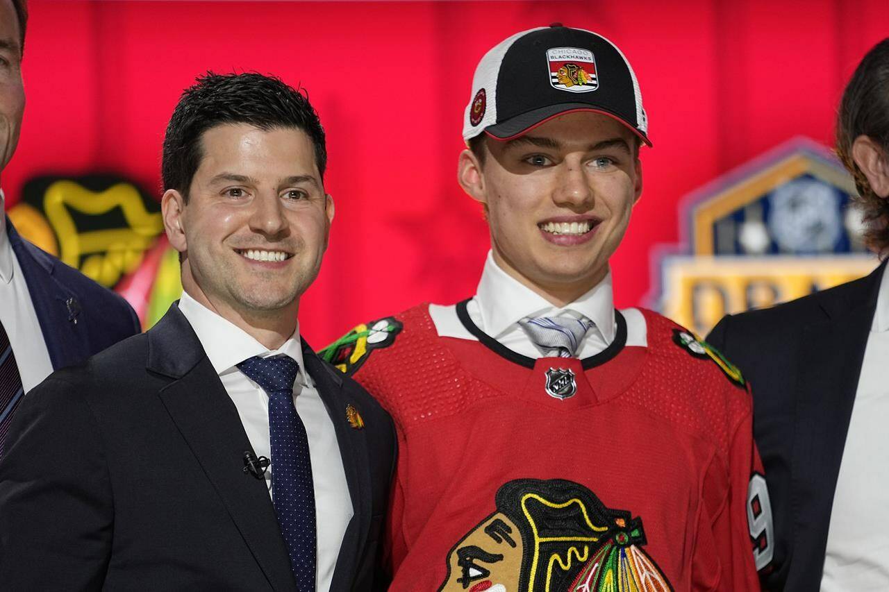 Chicago Blackhawks general manager Kyle Davidson poses with first round draft pick Connor Bedard during the first round of the NHL hockey draft, Wednesday, June 28, 2023, in Nashville, Tenn. (AP Photo/George Walker IV)