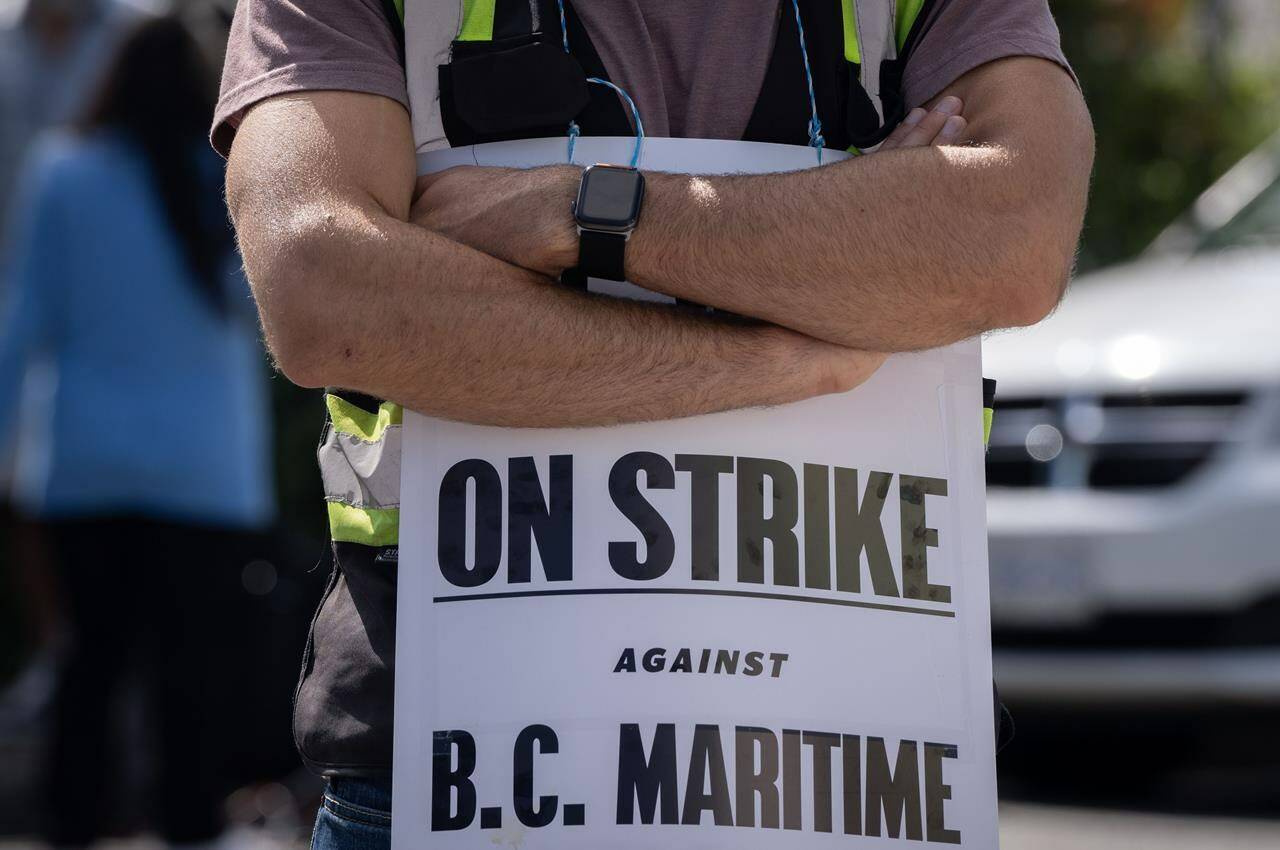 International Longshore and Warehouse Union workers picket outside of the BC Maritime Employers Association Dispatch Centre after a 72 hour strike notice and no agreement made on the bargaining table in Vancouver, on Saturday, July 1, 2023. The union representing thousands of striking British Columbia port workers says it plans to offer an update on negotiations later today. THE CANADIAN PRESS/Ethan Cairns