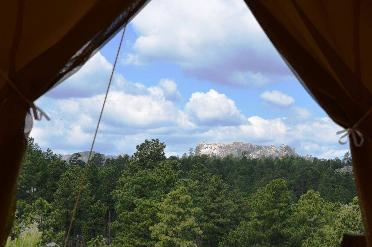 FILE - The view of Mount Rushmore located just a few miles away from Under Canvas Mount Rushmore tent cabins near Keystone, S.D. More than 10.5 million North American households took a glamping trip in 2022, up from 9.6 million in 2021. (Jim Holland/Rapid City Journal via AP, File)