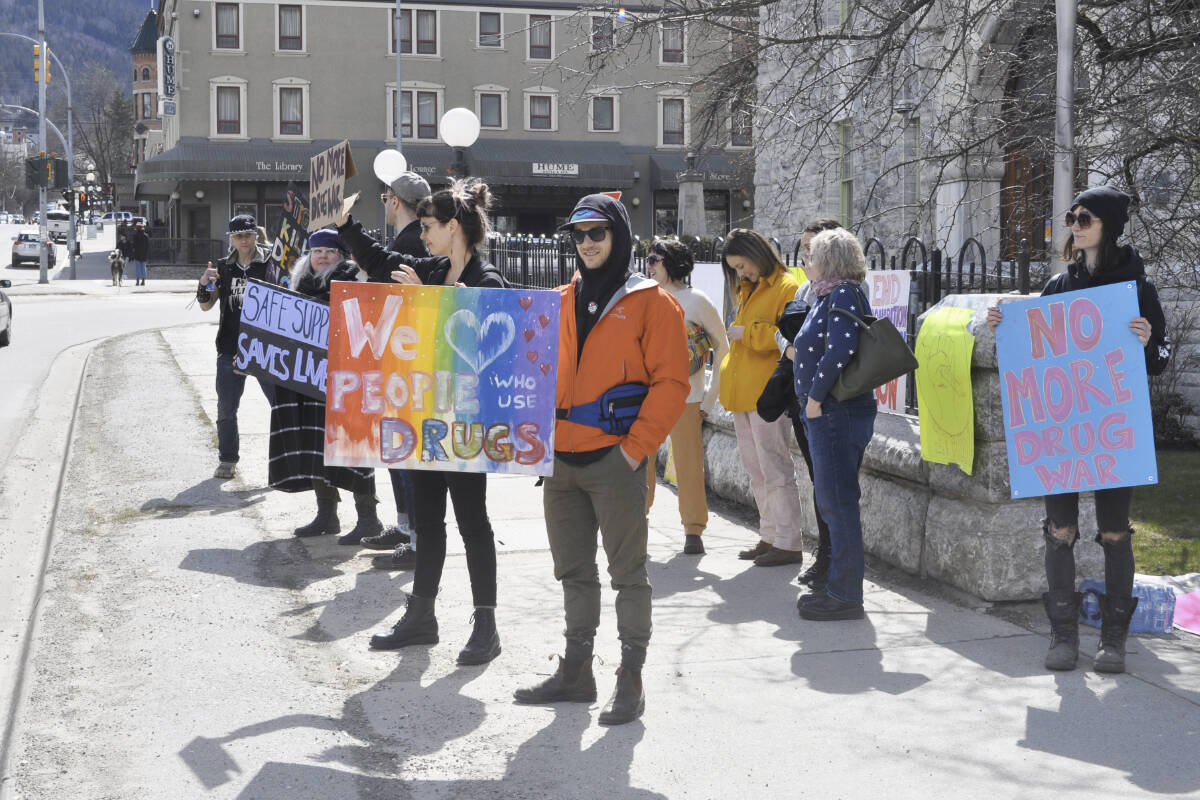 A group holds signs up outside Nelson City Hall in April during an event to mark the seventh anniversary of the toxic drug crisis. Photo: Tyler Harper