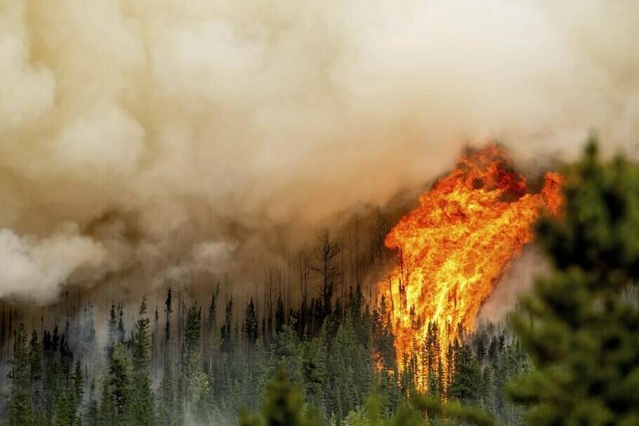 Flames from the Donnie Creek wildfire burn along a ridge top north of Fort St. John, British Columbia on Sunday, July 2, 2023. More campfire bans are on the way in B.C. as a heat wave in many areas is not expected to ease for days and a moderate to extreme wildfire risk covers all but the southeast corner of the province. THE CANADIAN PRESS/AP/Noah Berger