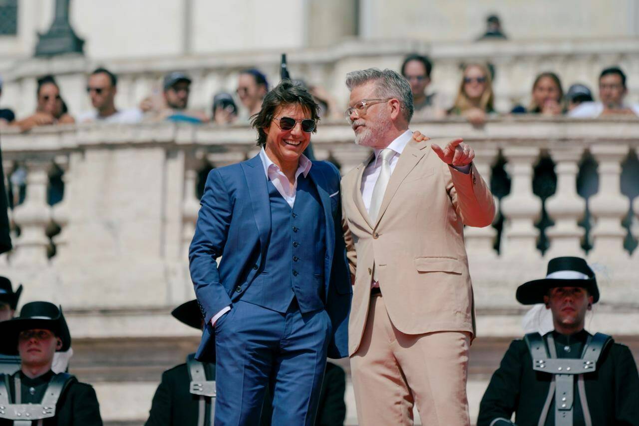 Actor Tom Cruise, left and director Chris McQuarrie pose for photographers on the red carpet of the world premiere for the movie “Mission: Impossible - Dead Reckoning” at the Spanish Steps in Rome Monday, June 19, 2023. (AP Photo/Alessandra Tarantino)