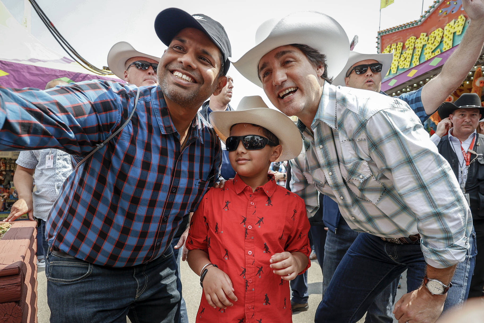 Prime Minister Justin Trudeau, right, pauses for a photo as he walks the grounds of the Calgary Stampede in Calgary, Friday, July 7, 2023. THE CANADIAN PRESS/Jeff McIntosh