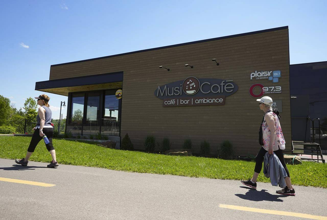 People walk past the new Musi-Cafe in Lac Megantic, Que. on Thursday, June 22, 2023. THE CANADIAN PRESS/Christinne Muschi