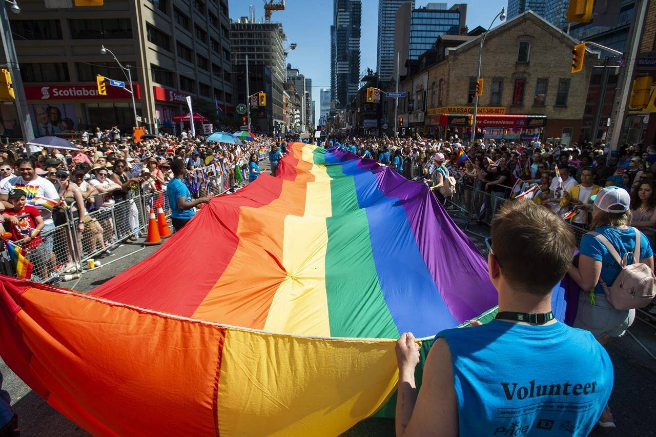 Volunteers with Pride Toronto carry a large rainbow flag during the 2019 Pride Parade in Toronto, Sunday, June 23, 2019. The city hosts its annual Pride parade today, with tens of thousands expected to join Canada’s largest LGBTQ celebration. THE CANADIAN PRESS/Andrew Lahodynskyj