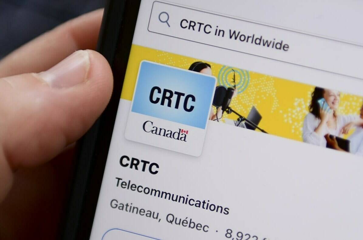 A person navigates to the online social media pages of the Canadian Radio-television and Telecommunications Commission (CRTC) on a cell phone in Ottawa on Monday, May 17, 2021. The federal telecommunications regulator says it will stick to the method it uses to set wholesale rates at which Canada’s large carriers provide smaller competitors with access to their services, with some tweaks. THE CANADIAN PRESS/Sean Kilpatrick