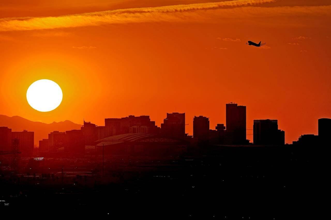 A Jet takes flight from Sky Harbor International Airport as the sun sets over downtown Phoenix, Wednesday, July 12, 2023. Millions of people around the Southwest are living through a historic heat wave. Even the heat-experienced desert city of Phoenix is being tested Wednesday as temperatures hit 110 degrees Fahrenheit for more than a dozen consecutive days. Phoenix is currently America's hottest large city with temperatures forecast to hit as high as 119 degrees Fahrenheit over the weekend. (AP Photo/Matt York)