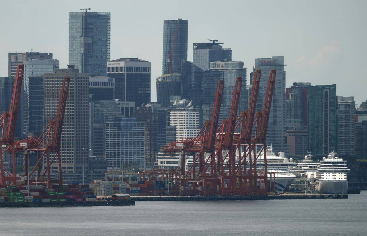 Gantry cranes sit idle above cruise ships and stacks of cargo containers at port during a strike by International Longshore and Warehouse Union Canada workers in the province in Vancouver on Wednesday, July 12, 2023. Work has resumed at British Columbia ports after both sides of the strike agreed to a tentative deal Thursday. THE CANADIAN PRESS/Darryl Dyck