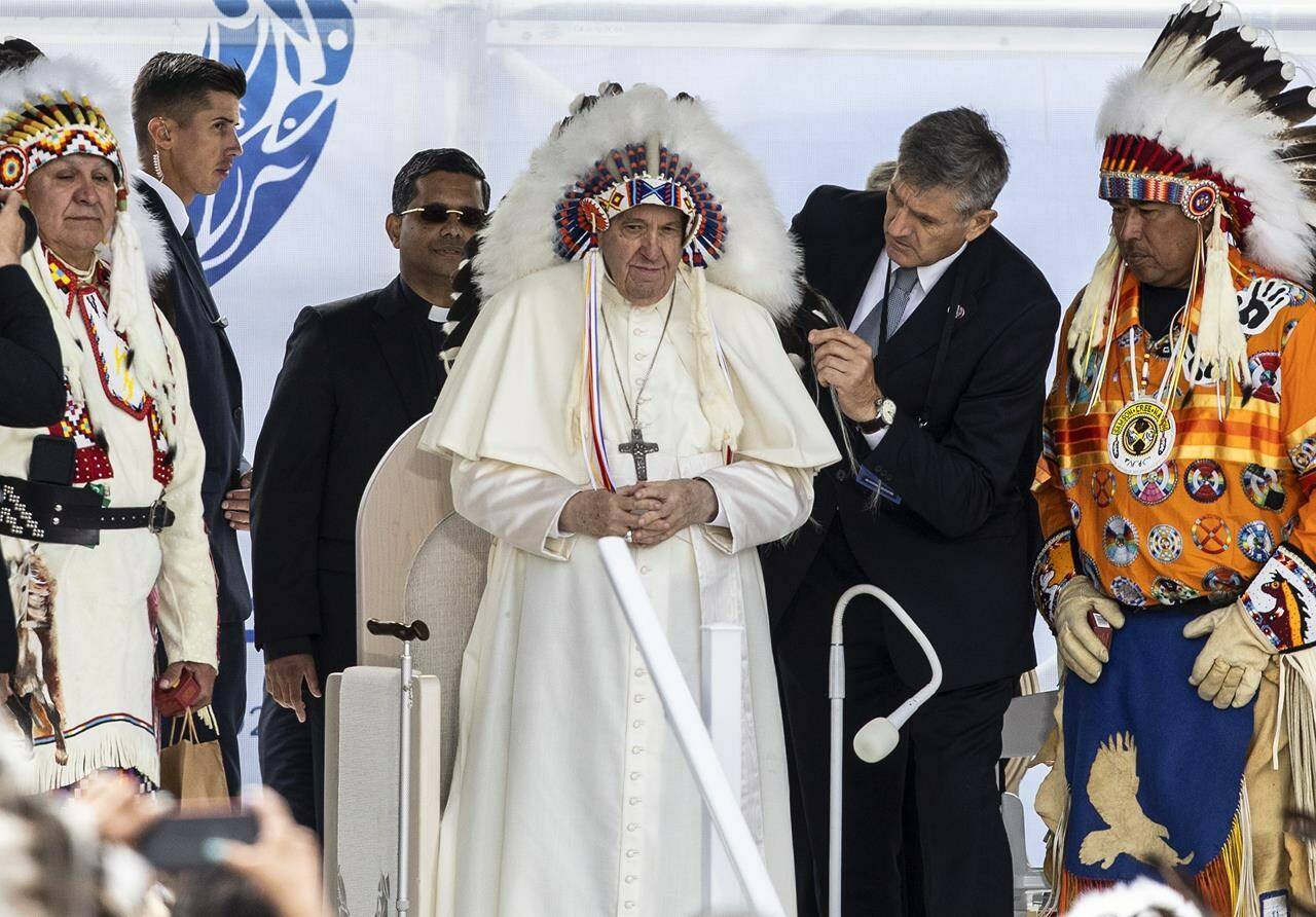Pope Francis receives a traditional headdress after apologizing for the Roman Catholic Church’s role in the residential school system, in Maskwacis, Alta., during his papal visit across Canada on Monday, July 25, 2022. THE CANADIAN PRESS/Jason Franson.