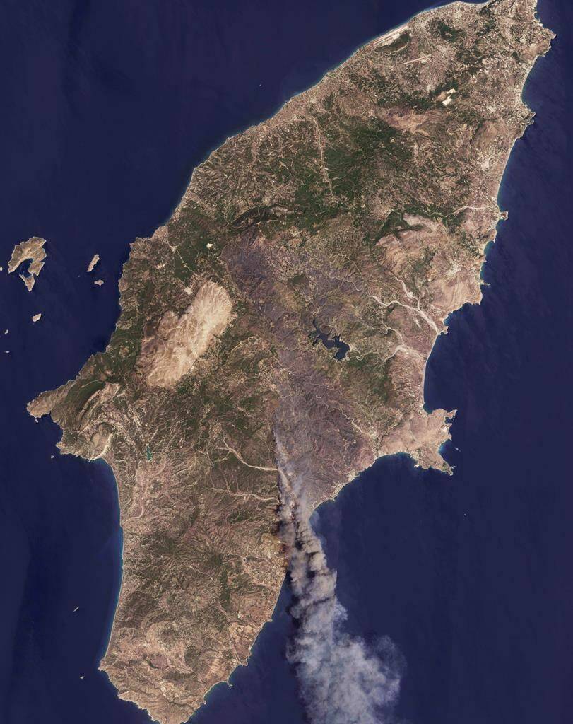 A satellite image from Planet Labs PBC shows the fires burning on the Greek resort island of Rhodes on Monday, July 24, 2023. A week-old wildfire on the Greek resort island of Rhodes tore past defenses Monday, forcing more evacuations as strong winds and successive heat waves that left scrubland and forests tinder-dry fueled three major fires raging elsewhere in Greece. (Planet Labs PBC via AP)