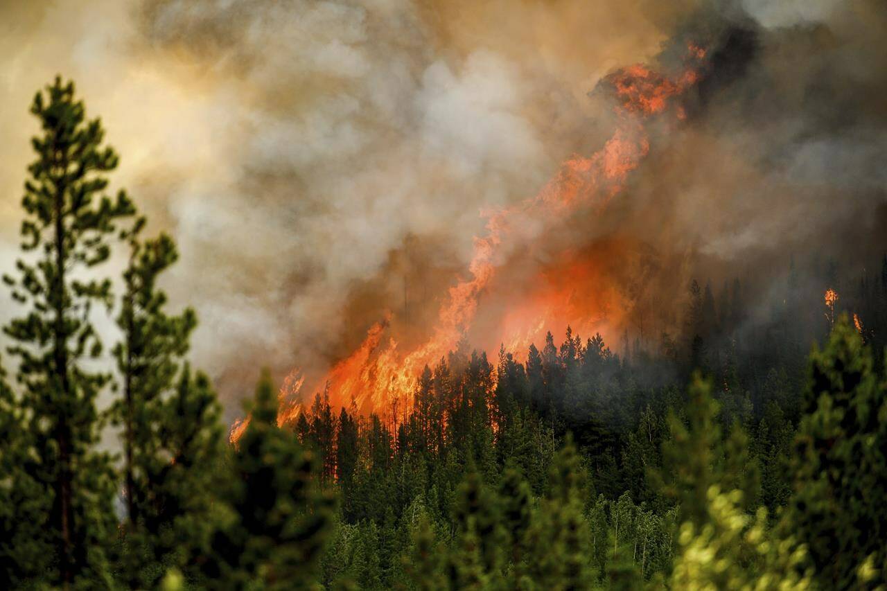 Flames from the Donnie Creek wildfire burn along a ridge top north of Fort St. John, B.C., on Sunday, July 2, 2023. THE CANADIAN PRESS/AP-Noah Berger