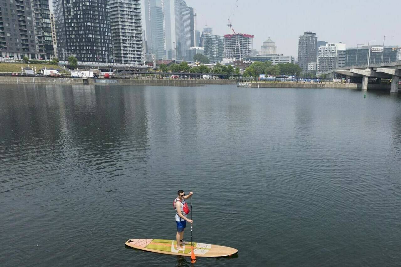 This summer has seen Environment Canada heat warnings for parts of the country used to baking in the heat, but also in places unaccustomed to extended periods of hot weather. Richar Gallego learns to paddle board on the Peel Basin, in Montreal, Friday, June 30, 2023. THE CANADIAN PRESS/Christinne Muschi