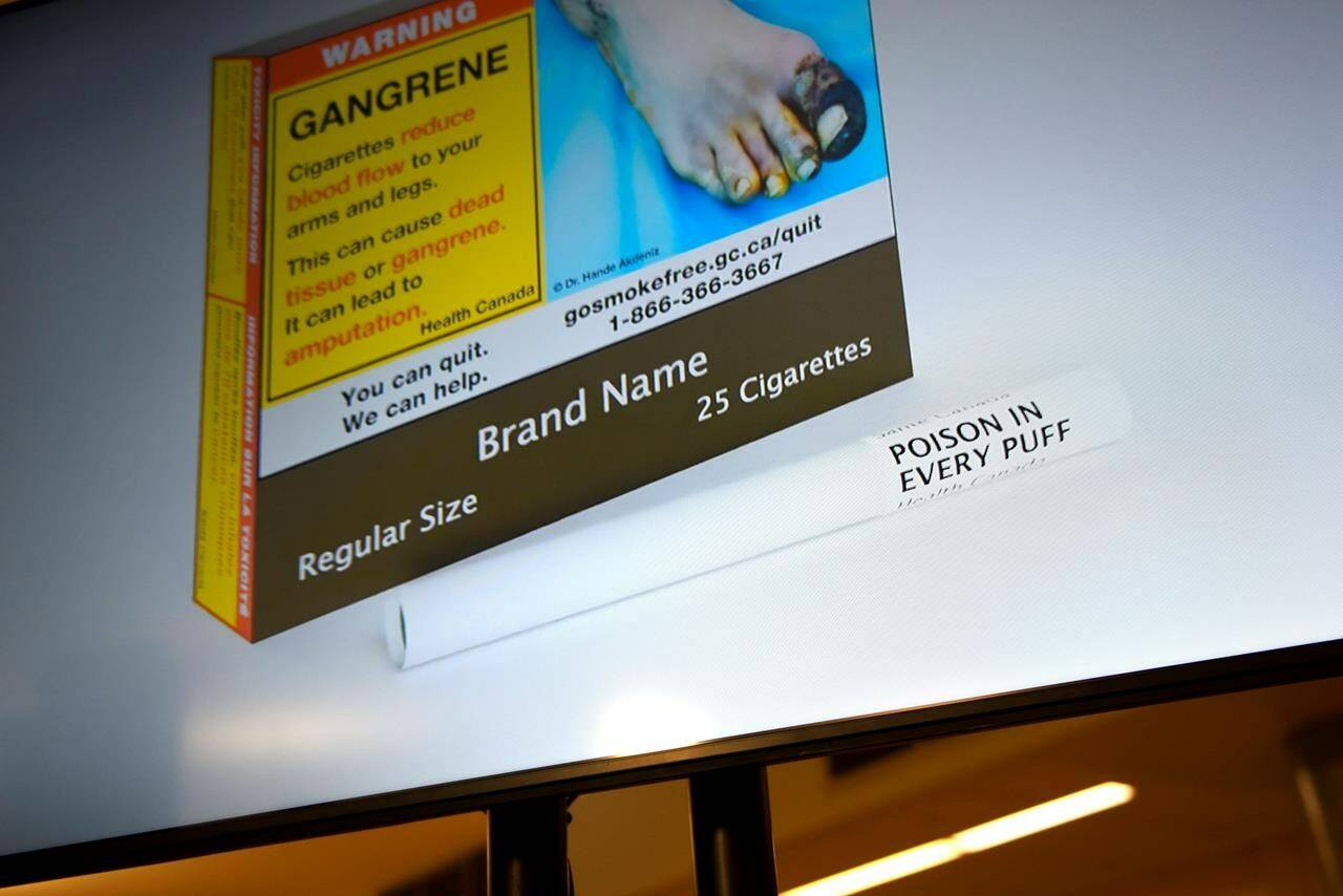 New Health Canada regulations that require warning labels to be printed on individual cigarettes are coming into effect tomorrow. An example of cigarette packaging with expanded warnings, including a warning printed on the cigarettes themselves, is shown on a screen after a news conference, in Ottawa, Friday, June 10, 2022. THE CANADIAN PRESS/Justin Tang