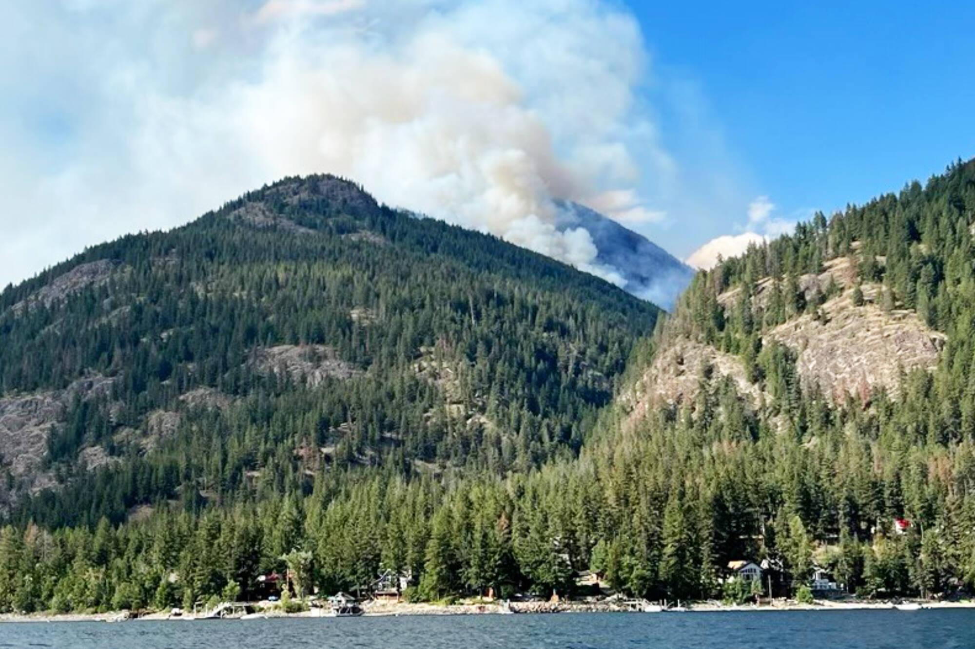 The Lower Adams Lake East wildfire burns in the mountains above lakeshore properties currently under an evacuation alert. (CSRD photo)