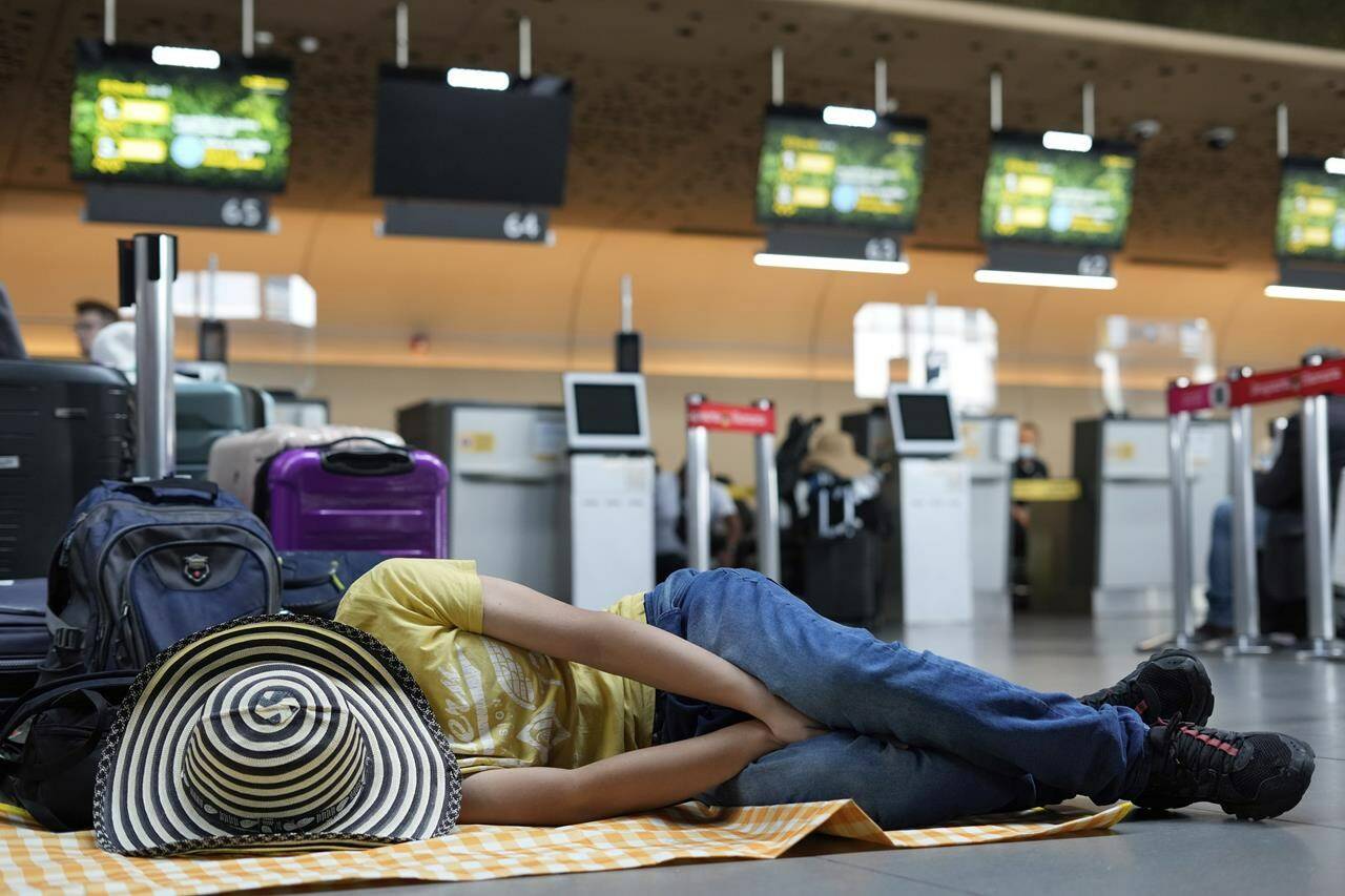 FILE - A Viva Air passenger sleeps at the airport after the low-cost airline suspended its operations at the El Dorado International Airport in Bogota, Colombia, Feb. 28, 2023. Two to three hours is generally the minimum recommended time for an international layover, but in some cases that might not even be sufficient. Account for time to clear customs and go through security again, and you might also need to retrieve and recheck luggage. (AP Photo/Fernando Vergara)