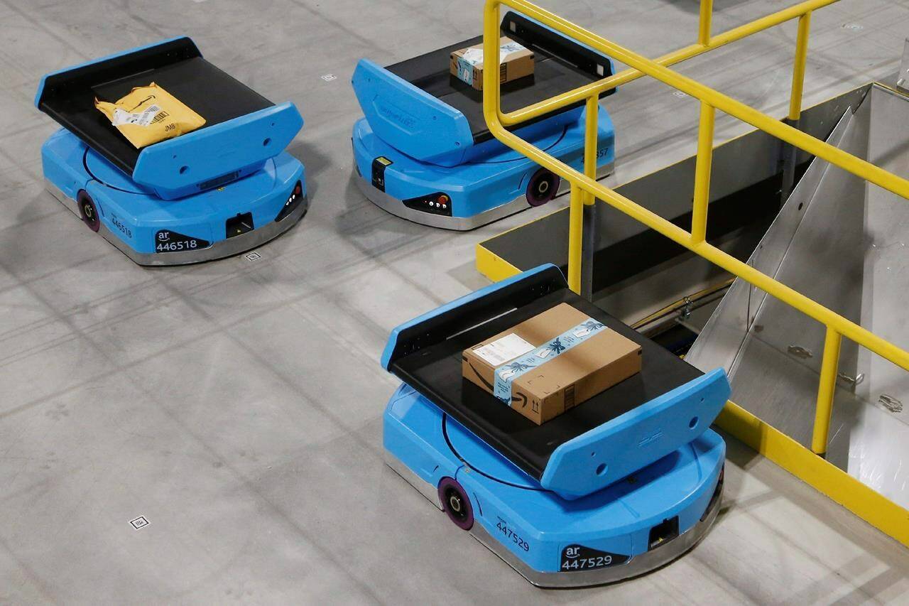 Amazon robots move along the warehouse floor with packages before finding the proper delivery chute, at an Amazon warehouse facility in Goodyear, Ariz. Tuesday, Dec. 17, 2019. Amazon Canada says it will open a new robotics-based fulfillment centre south of London, Ont. later this year. THE CANADIAN PRESS/AP-Ross D. Franklin