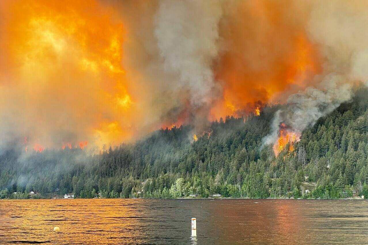 The Downton Lake wildfire near Gold Bridge B.C., burns toward the north shore of Gun Lake in this Tuesday, August 1, 2023 handout photo. THE CANADIAN PRESS/HO, Owen Rose
