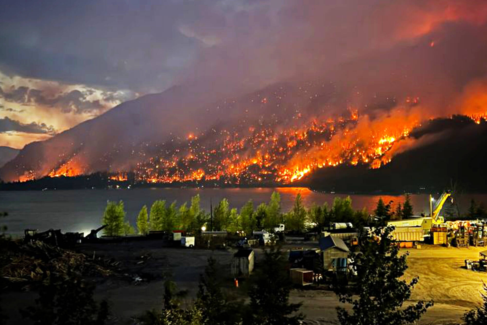 The East Adams Lake wildfire spreads across the lake from Interfor’s Adams Lake mill on Wednesday night, Aug. 2, 2023. (Rick Kwitkoski/Facebook photo)