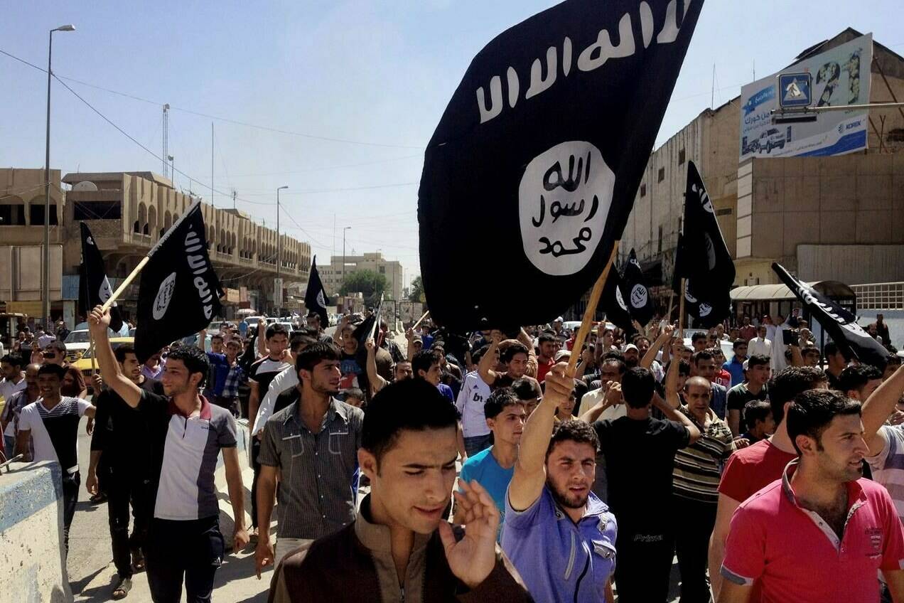 FILE - Demonstrators chant pro-Islamic State group slogans as they carry the group’s flags in front of the provincial government headquarters in Mosul, Iraq, June 16, 2014. The Islamic State group announced Thursday the death of its little known leader Abu al-Hussein al-Husseini al-Qurayshi who had been heading the extremist organization since November. (AP Photo, File)