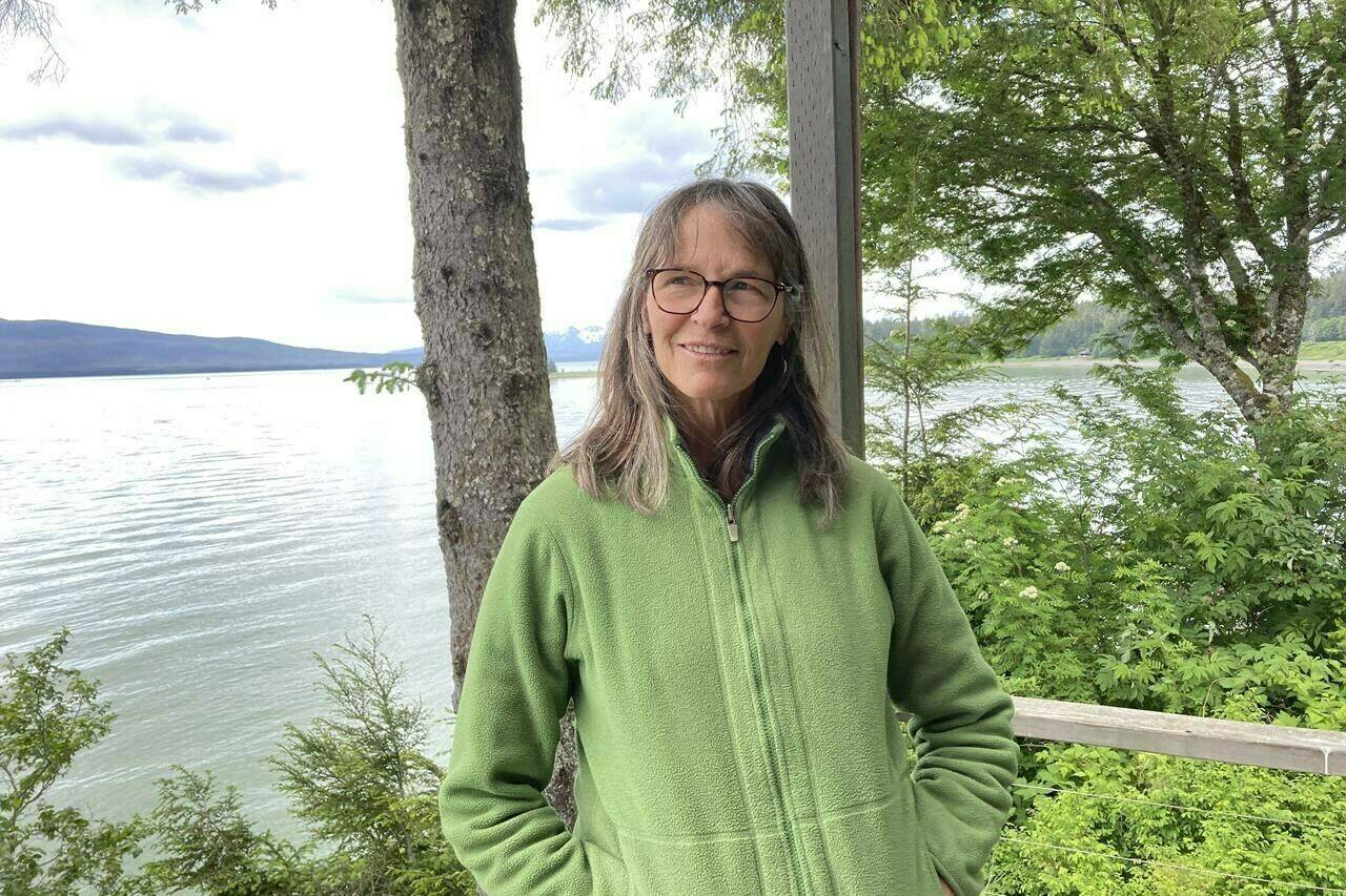 Kerry Kirkpatrick, a resident of Juneau, Alaska, poses outside her home on June 13, 2023. Kirkpatrick is concerned with the sustainability of the current level of tourism in Juneau. The city is expecting a record number of cruise passengers this year.(AP Photo/Becky Bohrer)