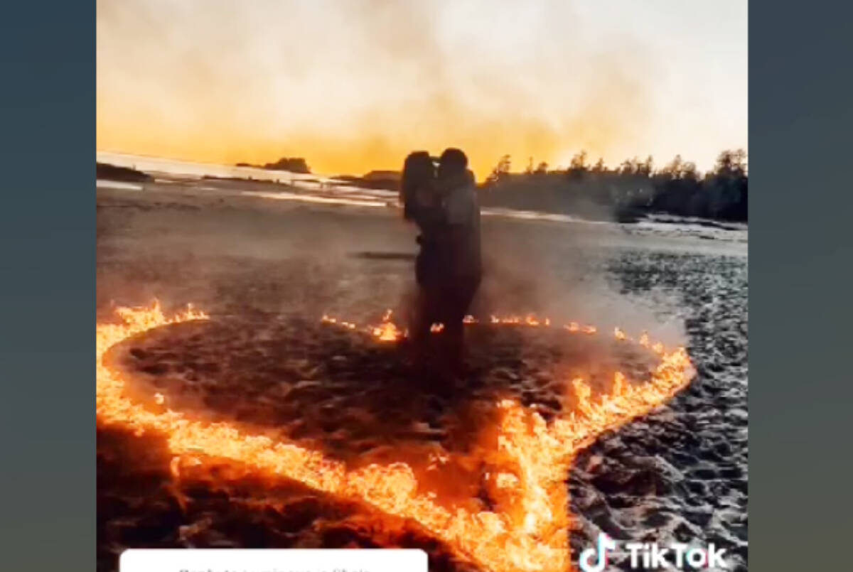A screenshot of a TikTok video posted on Monday that shows a couple embracing in the middle of a heart-shaped fire set on a Tofino beach during a fire ban and severe drought that has the community currently in Stage 3 water restrictions.