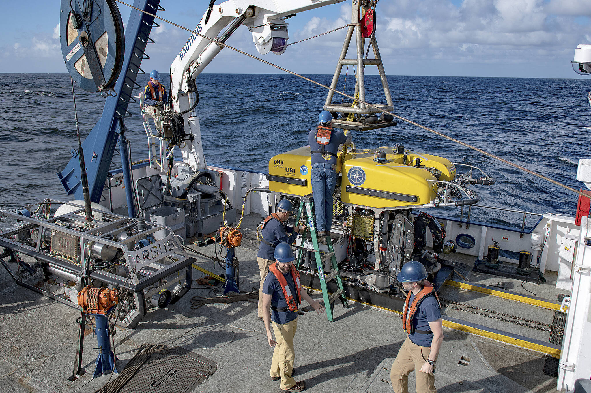 Staff aboard the Nautilus exploration ship prepare to place a remote controlled vehicle into the ocean to search for meteorites that fell in March 2018 (Susan Poulton/Ocean Exploration Trust).