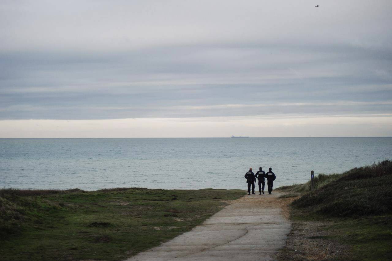 FILE - French police officers patrol on the beach in the searcher migrants in Wimereux, northern France, Wednesday, Nov.17, 2021. Six people died and more than 50 were rescued when a boat carrying migrants capsized Saturday (Aug. 12, 2023) in the English Channel, according to French authorities.. (AP Photo/Louis Witter, File)