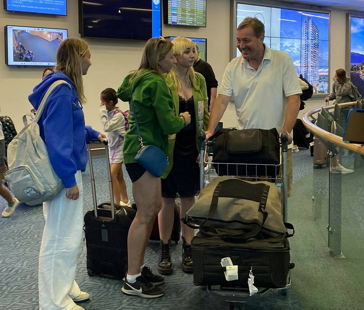 Matthew Taylor (right) and family members return from Maui to Vancouver International Airport on Friday, Aug. 11, 2023. Canadians returning from Maui have told of harrowing scenes before their escape from the fire-devastated Hawaiian island.