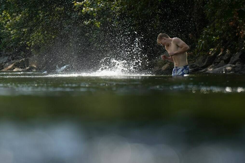 A person cools off in Lynn Creek in North Vancouver, B.C., on Thursday, July 6, 2023. Health authorities as well as local and provincial governments across British Columbia are providing guidance on how best to deal with a sweltering heat wave that began in British Columbia’s southern coast this weekend is expected to expand into the Interior starting today.THE CANADIAN PRESS/Darryl Dyck