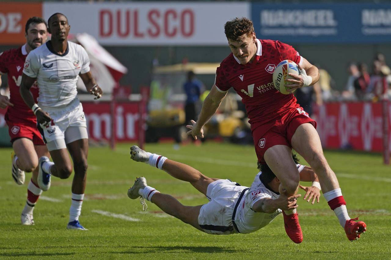 Canada’s Phil Berna, right, is tackled by Lucas Lacamp from the U.S., during a match of the Emirates Airline Rugby Sevens, in Dubai, United Arab Emirates, Friday, Dec. 2, 2022. Berna and Olivia Apps will captain the Canadian sides looking to secure Olympic qualification at the Rugby Americas North (RAN) Sevens next weekend in Langford, B.C. THE CANADIAN PRESS/AP-Kamran Jebreili