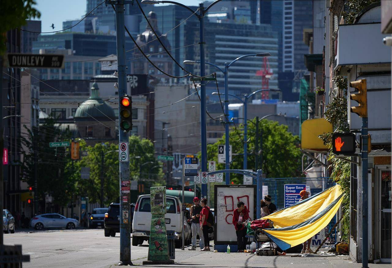 An outreach team for the Union Gospel Mission in Vancouver has been working in the city’s Downtown Eastside to ensure people are aware and are prepared to cope with the latest heat spike across parts of B.C. A tarp is seen draped between a building and a shopping cart to provide shade from the sun in the Downtown Eastside of Vancouver, on Saturday, May 13, 2023. THE CANADIAN PRESS/Darryl Dyck