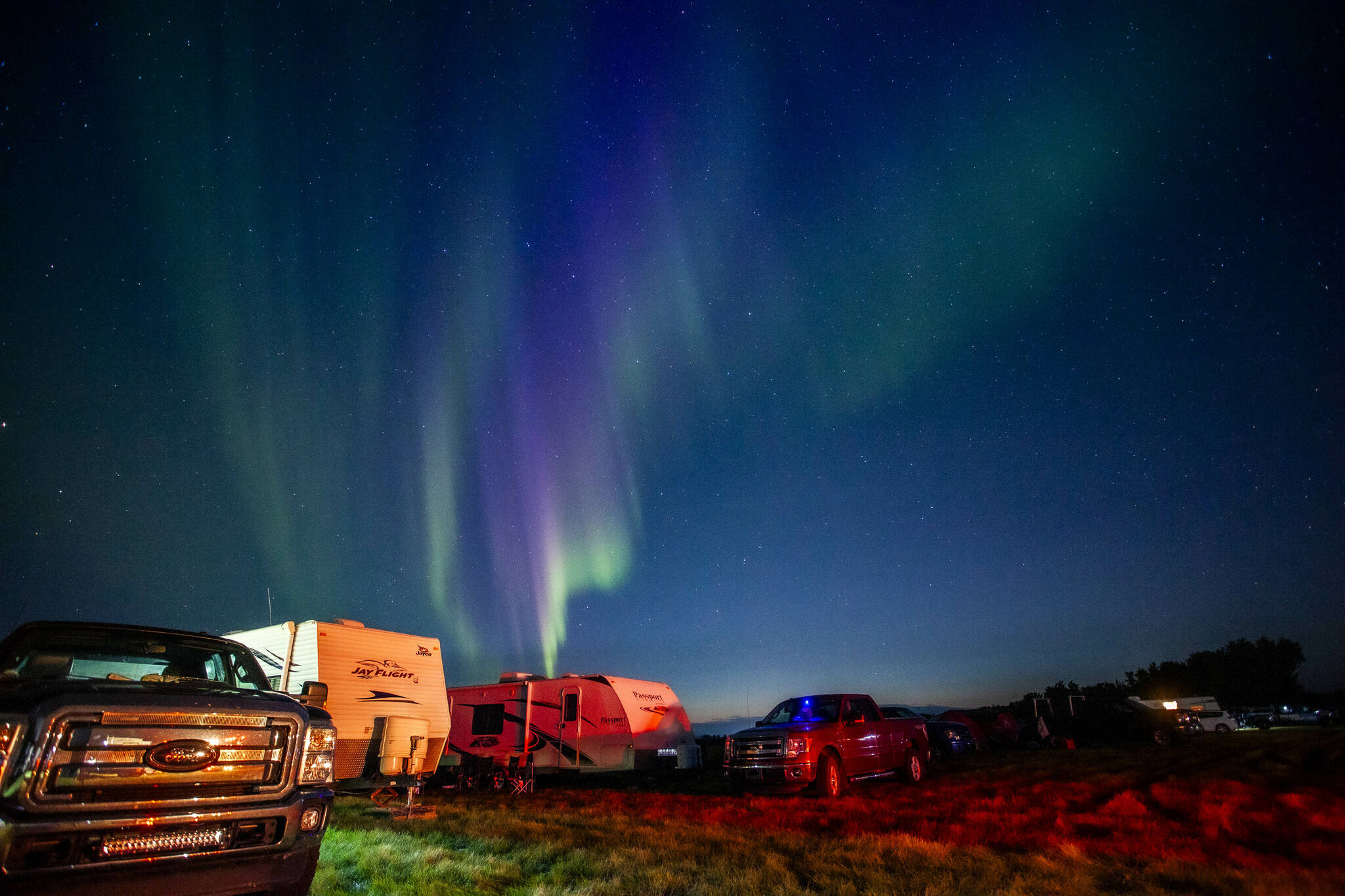 Evacuees from Yellowknife, territorial capital of the Northwest Territories, are greeted with the Aurora Borealis as they arrive to a free campsite provided by the community in High Level, Alta., Thursday, Aug. 17, 2023. THE CANADIAN PRESS/Bill Braden