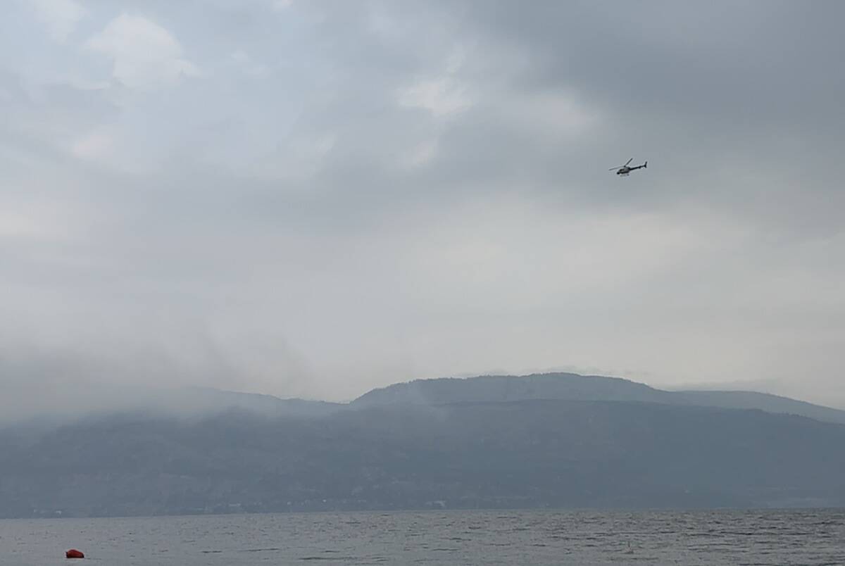 A helicopter flies over Okanagan Lake Tuesday morning (Aug. 22) to assess the Clarke Creek wildfire in Lake Country. (Jordy Cunningham/Capital News)
