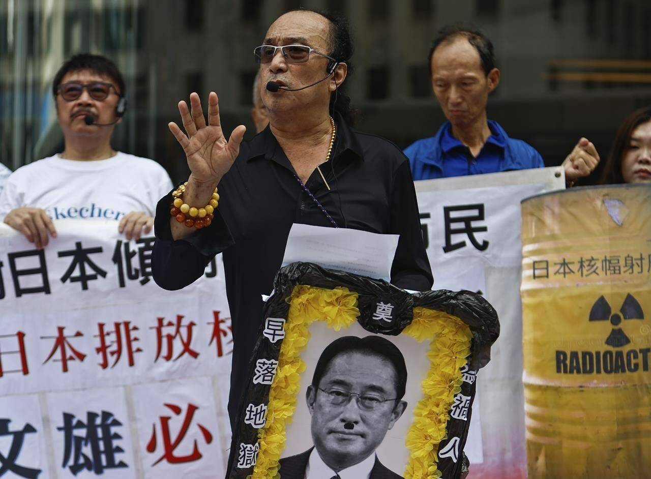 A protester holds up a funeral portrait depiction of Japanese Prime Minister Fumio Kishida during a protest against the discharge of treated Fukushima radioactive wastewater, outside the Japan general-consulate in Hong Kong, on Thursday, Aug. 24, 2023. The Hong Kong authorities have imposed a ban on imports of Japanese seafood as a gesture to oppose Japan’s decision to discharge the treated radioactive water from the wrecked Fukushima nuclear power plant. (AP Photo/Daniel Ceng)