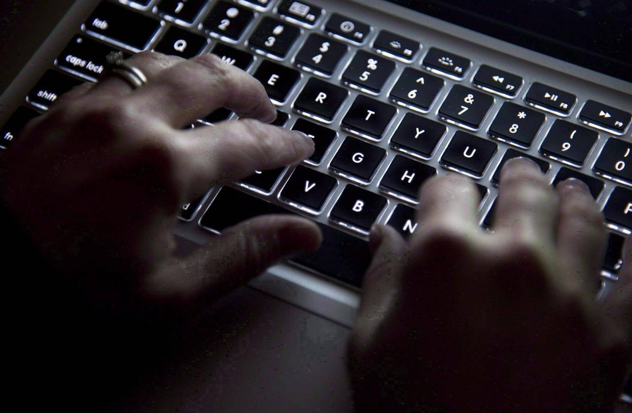A new federal report predicts Russian intelligence services and police will help cybercriminals operate with “near impunity” against their targets — including Canadians — in coming months. A woman uses her computer keyboard to type in North Vancouver, B.C., on Dec. 19, 2012. THE CANADIAN PRESS/Jonathan Hayward
