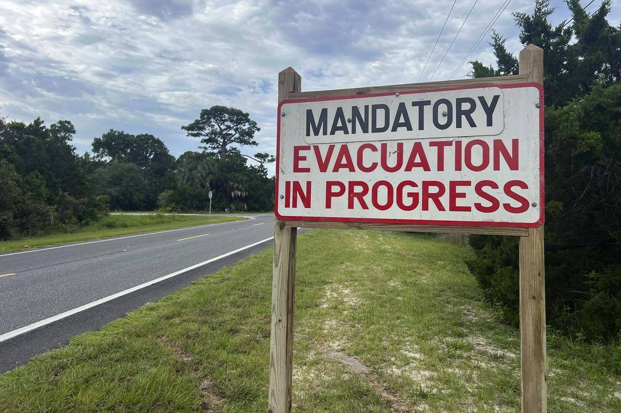 An evacuation sign stands in Cedar Key, Fla., on Tuesday, Aug. 29, 2023. Idalia strengthened into a hurricane Tuesday and barreled toward Florida's Gulf Coast as authorities warned residents of vulnerable areas to pack up and leave to escape the twin threats of high winds and devastating flooding. (AP Photo/Daniel Kozin)