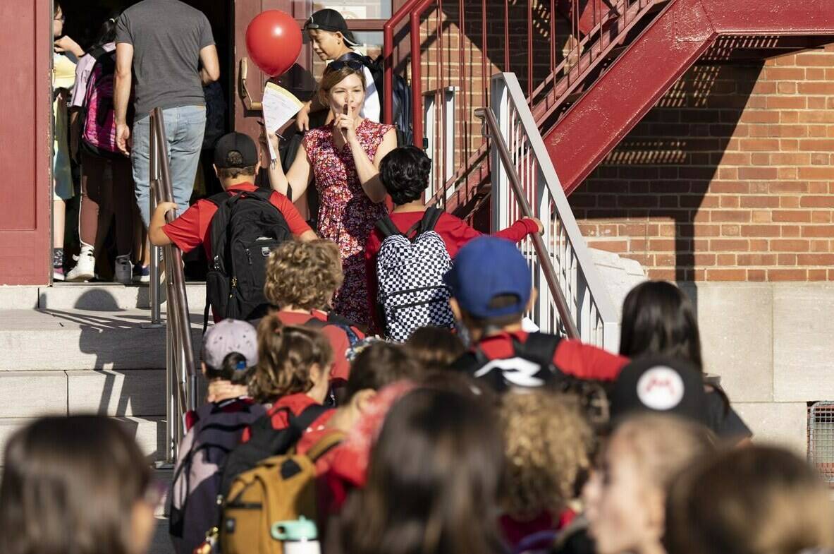 Some of the largest school boards across Canada will begin the new school year without formal policies on the use of artificial intelligence in the classroom, despite concerns about how the technology will impact learning and academic integrity. Grade 3 teacher Catherine Rioux-Tache leads her students into class at Sainte-Cecile elementary school on their first day back to school in Montreal, Monday, Aug. 28, 2023. THE CANADIAN PRESS/Christinne Muschi