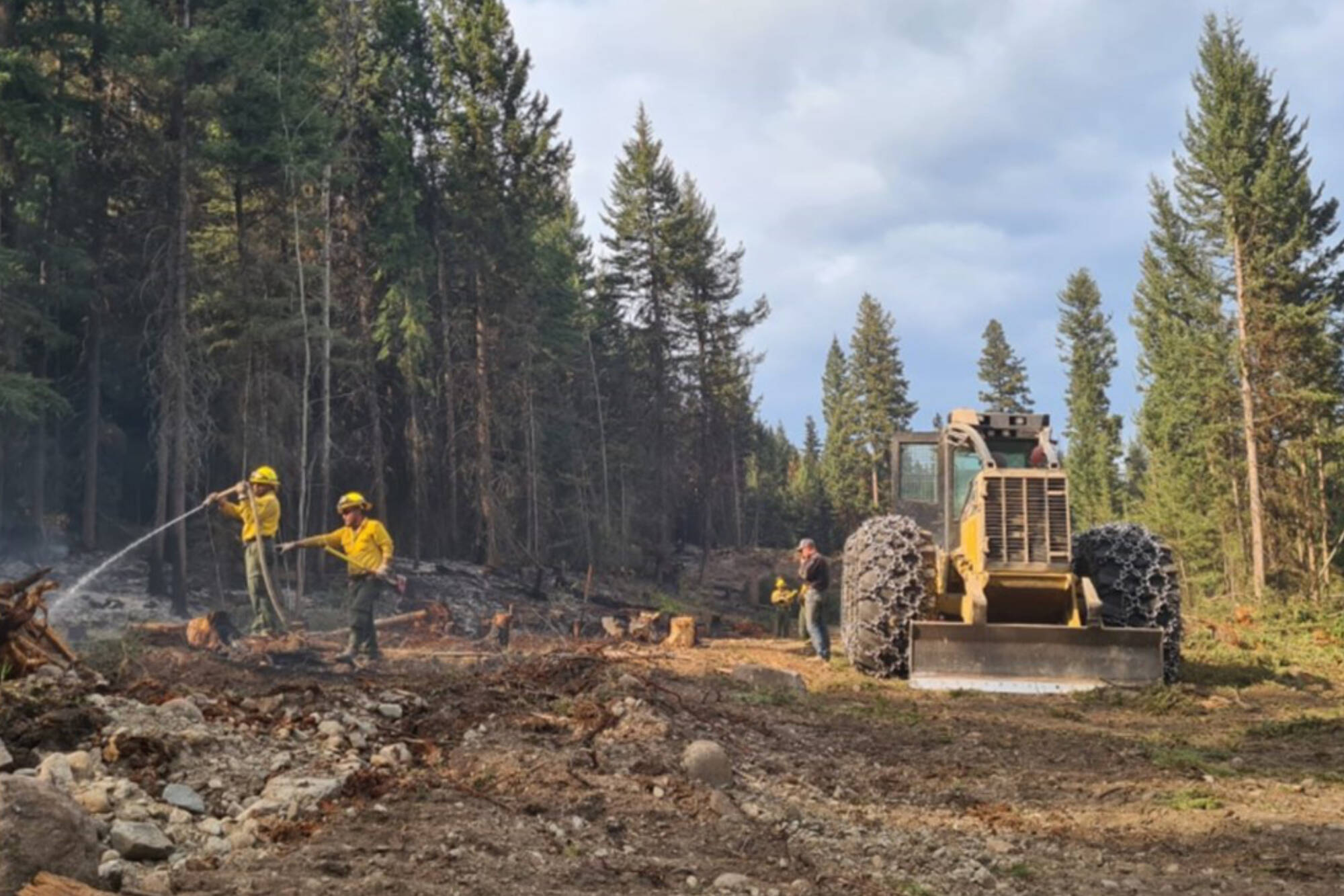 Firefighters hose down a spot within the Bush Creek East wildfire perimeter. (BCWS photo)
