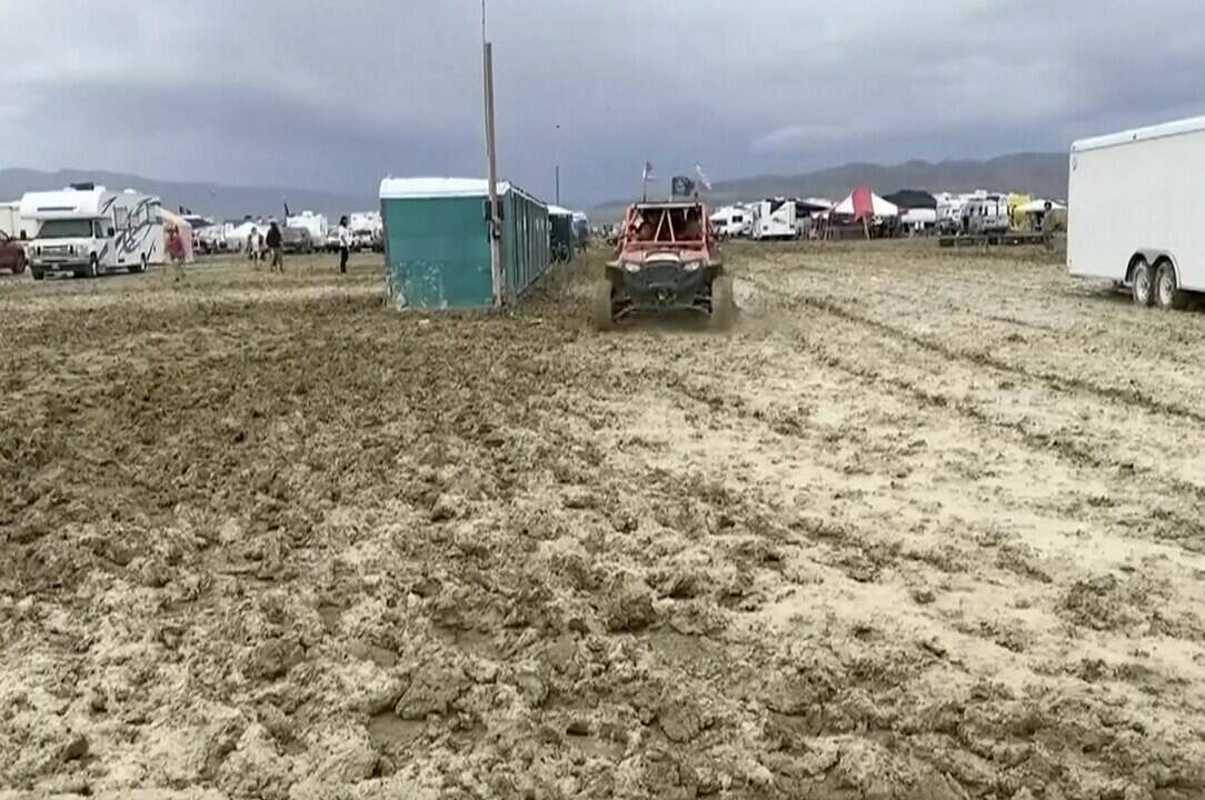 In this image from video provided by Rebecca Barger a vehicle drives through mud at the Burning Man festival site in Black Rock, Nev., on Monday, Sept. 4, 2023. An unusual late-summer storm stranded thousands at the week-long event. (Rebecca Barger/@rebeccabargerphoto via AP)