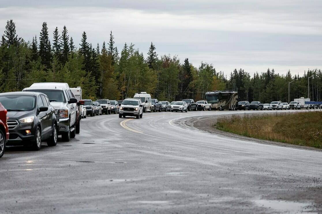 Vehicles line up for fuel at Fort Providence, N.W.T., on the only road south from Yellowknife, Thursday, Aug. 17, 2023. Thousands of vehicles are expected to travel to Yellowknife in the coming days as a three-week evacuation order is set to lift at noon. THE CANADIAN PRESS/Jeff McIntosh