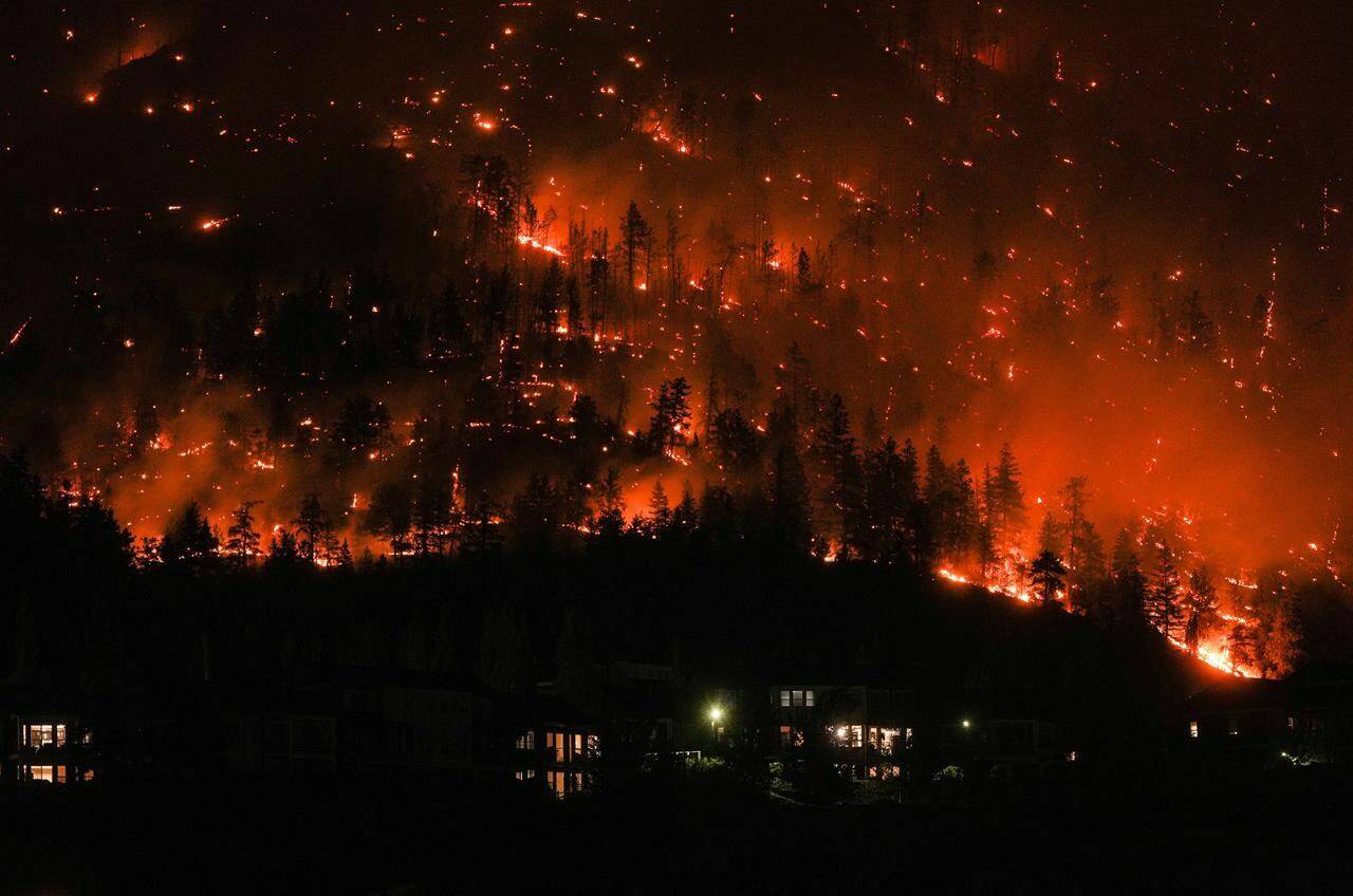 The latest federal government forecast says Canada’s already unprecedented 2023 wildfire season could continue late into the fall or winter. The McDougall Creek wildfire burns on the mountainside above houses in West Kelowna, B.C., on Friday, August 18, 2023. THE CANADIAN PRESS/Darryl Dyck